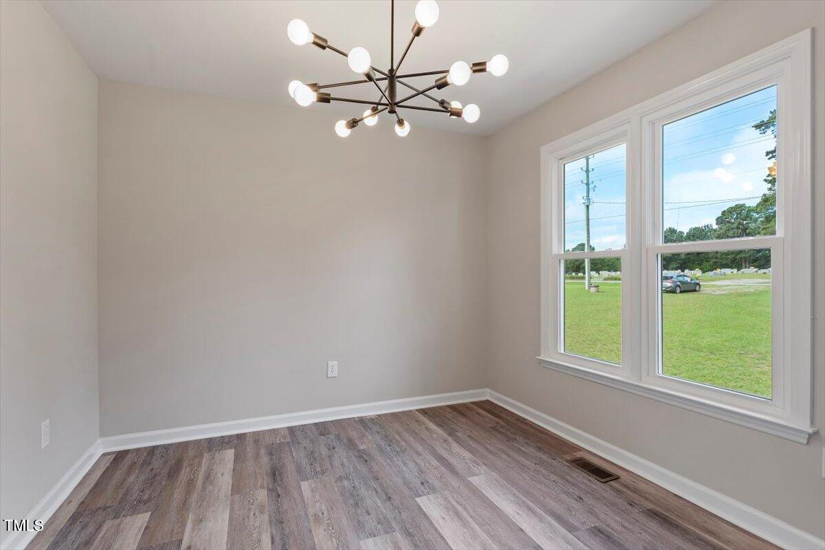1480 White Memorial Church Road Willow Spring, NC 27592 - Photo 11 of 23 a view of an empty room with wooden floor and a window