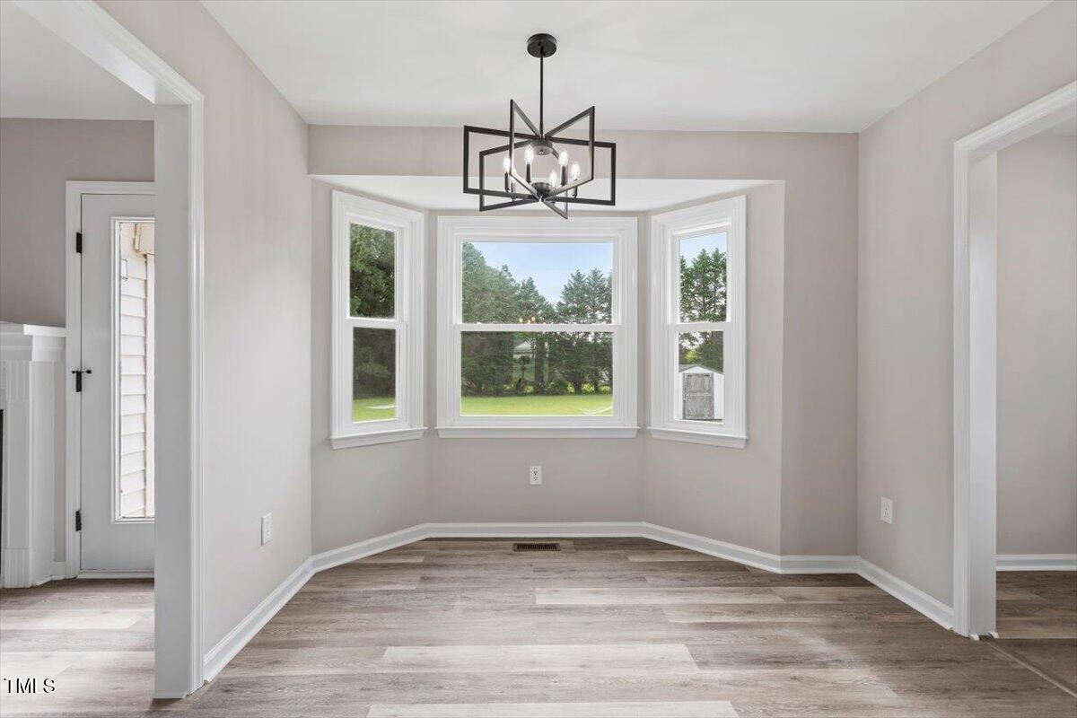 1480 White Memorial Church Road Willow Spring, NC 27592 - Photo 12 of 23 a view of an empty room with wooden floor and windows