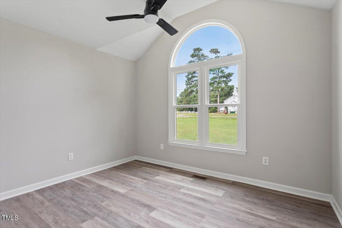 1480 White Memorial Church Road Willow Spring, NC 27592 - Photo 18 of 23 an empty room with wooden floor fan and windows