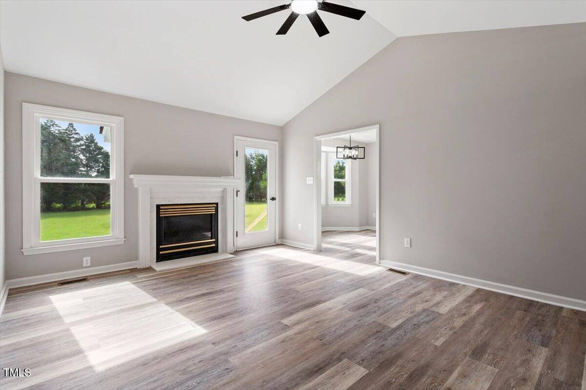1480 White Memorial Church Road Willow Spring, NC 27592 - Photo 4 of 23 an empty room with windows fireplace and wooden floor