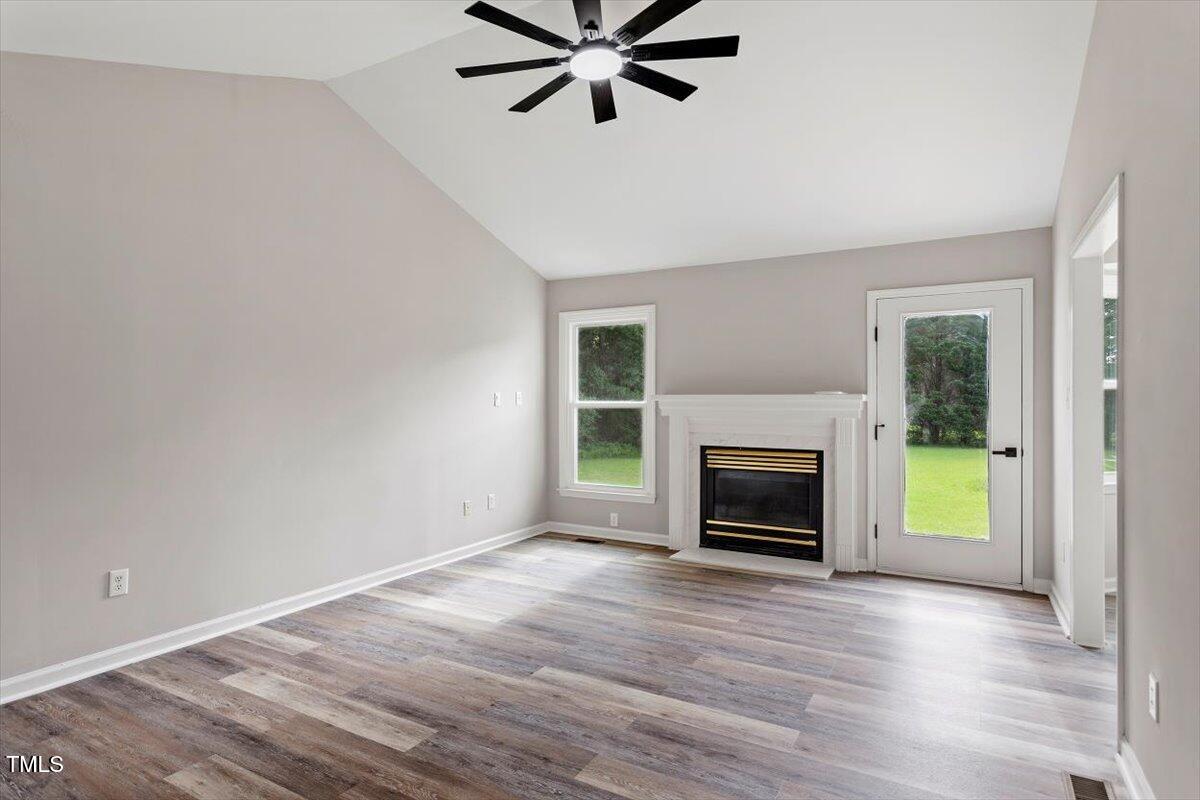 1480 White Memorial Church Road Willow Spring, NC 27592 - Photo 5 of 23 a view of a livingroom with a fireplace a ceiling fan and wooden floor