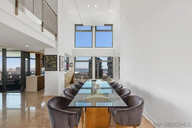 a living room with couches and kitchen view with wooden floor