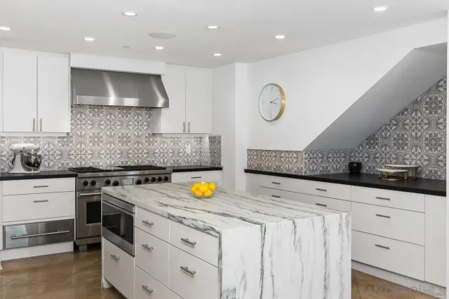 a kitchen with a sink and chairs