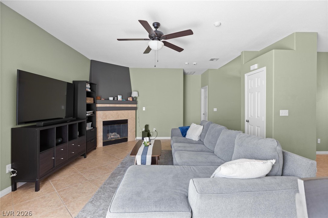 3238 Mystic Ridge Court Las Vegas, NV 89129 - Photo 3 of 31 An inviting living room, featuring a cozy fireplace and practical tile flooring.