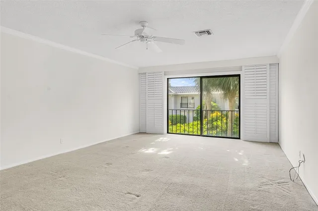 an empty room with potted plants and a ceiling fan