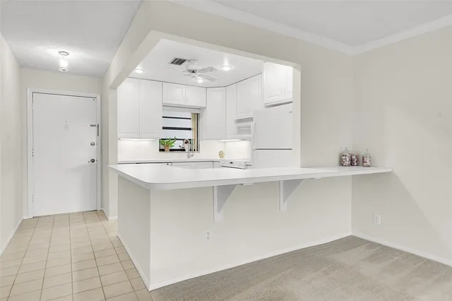 a kitchen with kitchen island white cabinets and refrigerator