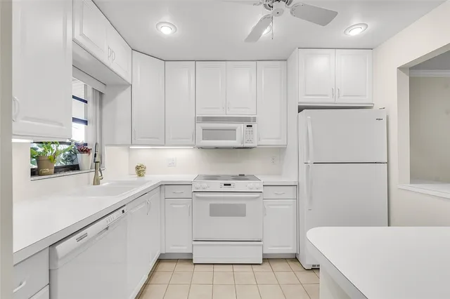 a kitchen with white cabinets and white appliances