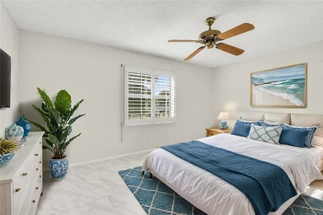 a bedroom with a large bed and a potted plant