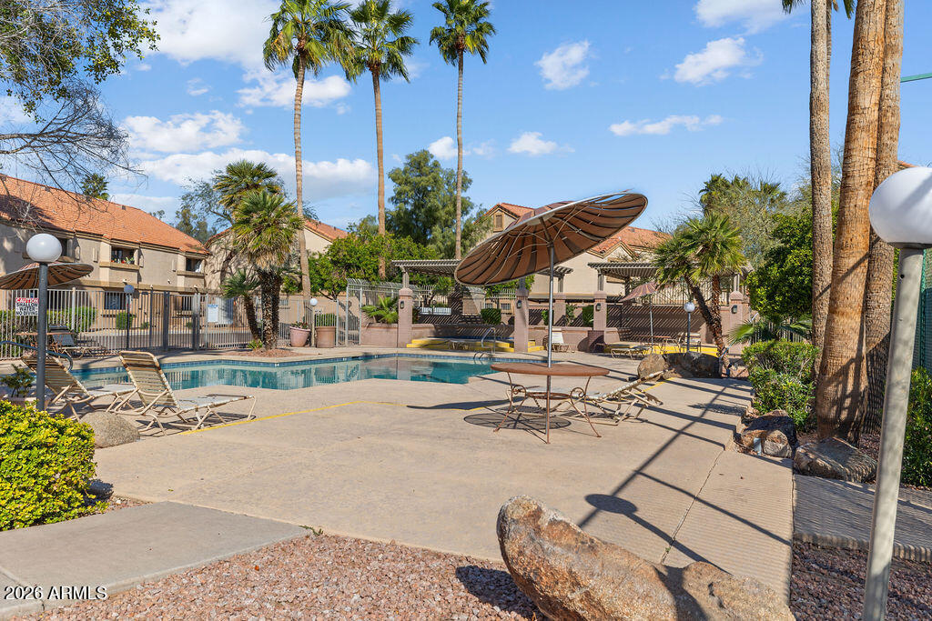 1287 North Alma School Road, Unit 123 Chandler, AZ 85224 - Photo 25 of 26 a view of a swimming pool with a table and chairs