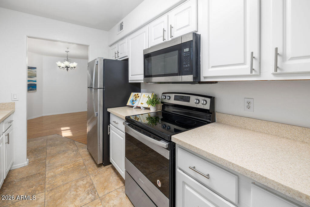 1287 North Alma School Road, Unit 123 Chandler, AZ 85224 - Photo 6 of 26 a kitchen with stainless steel appliances a stove microwave and refrigerator