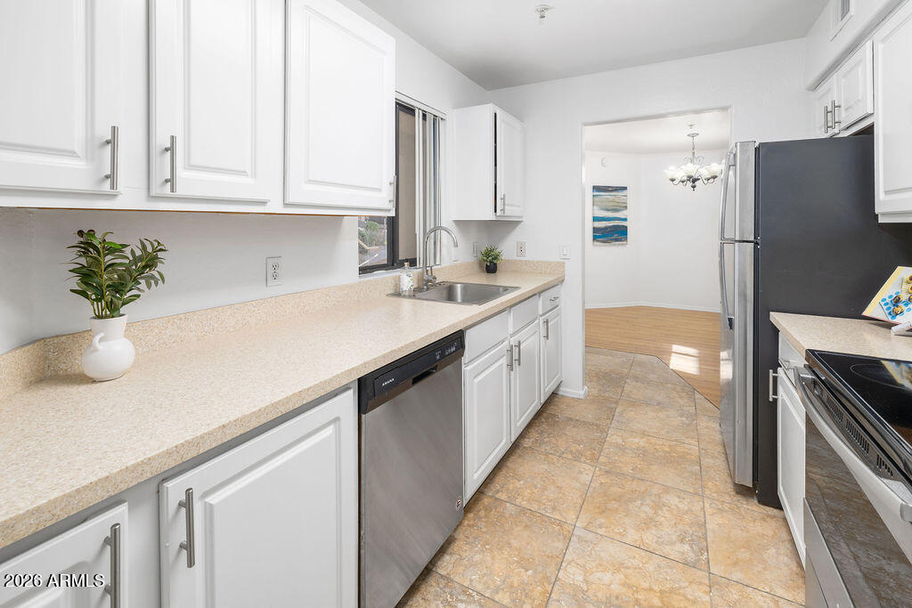 1287 North Alma School Road, Unit 123 Chandler, AZ 85224 - Photo 7 of 26 a kitchen with stainless steel appliances granite countertop a sink a stove and a refrigerator