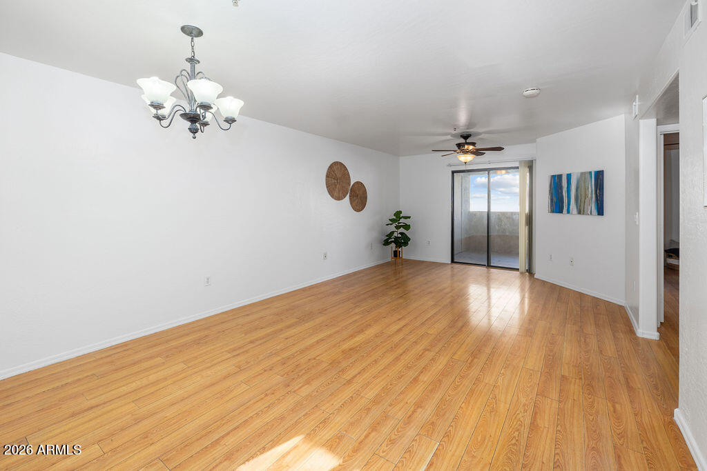 1287 North Alma School Road, Unit 123 Chandler, AZ 85224 - Photo 8 of 26 a view of a room with wooden floor and chandelier