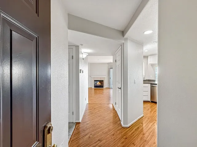 a view of a hallway with wooden floor and staircase