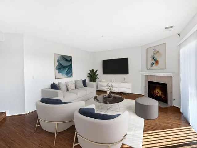 a living room with furniture a flat screen tv and a fireplace