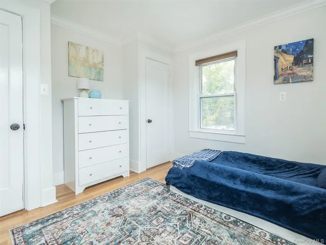 a living room with a dresser and a window