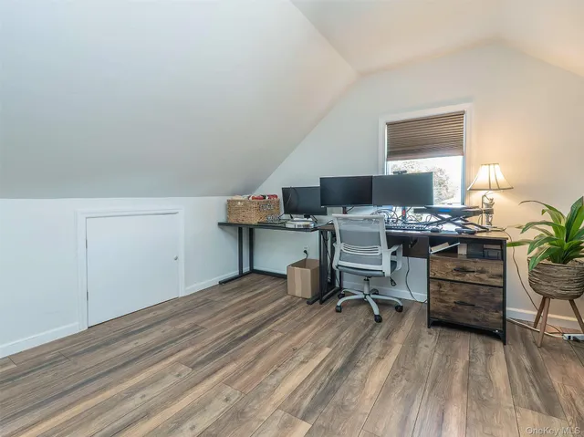 a view of a workspace with furniture and a window