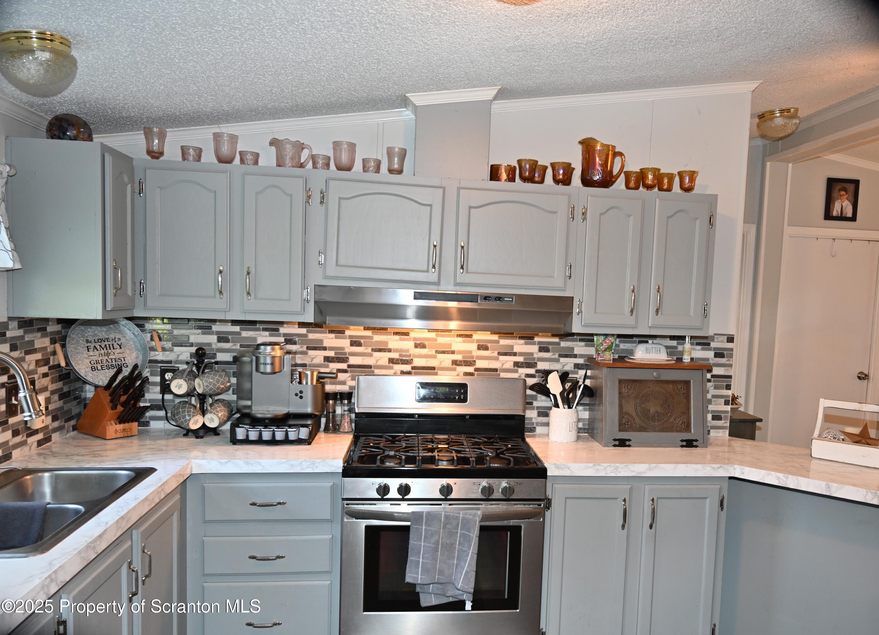 68 Spring Street Great Bend, PA 18821 - Photo 5 of 32 a kitchen with granite countertop a stove sink and cabinets