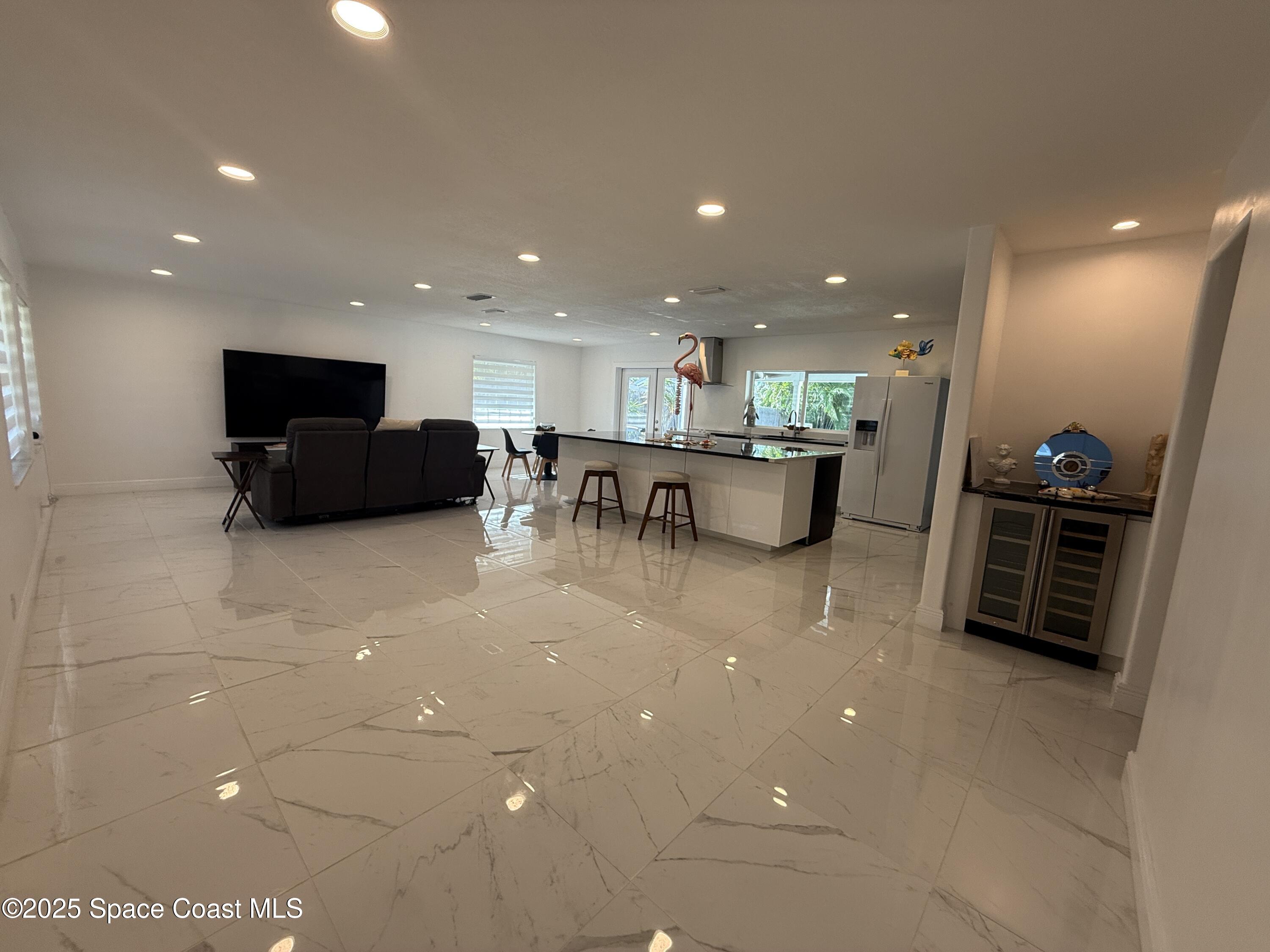 306 School Road Indian Harbour Beach, FL 32937 - Photo 3 of 21 a living room with stainless steel appliances furniture a rug and a kitchen view