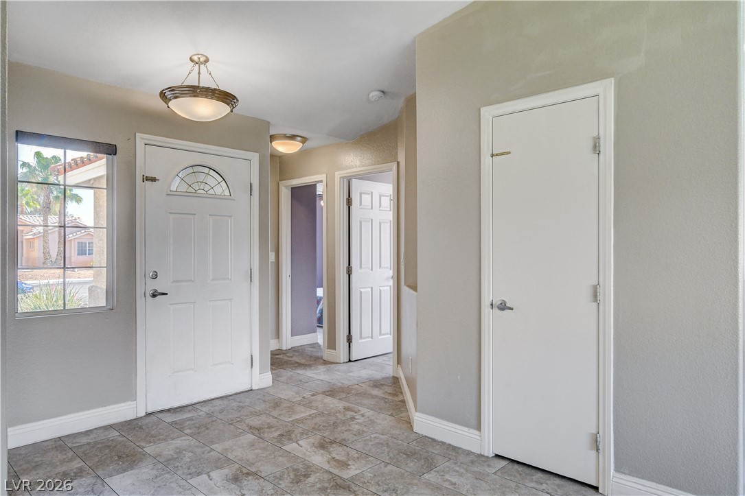 910 Cobblestone Cove Road North Las Vegas, NV 89081 - Photo 16 of 30 A well-lit entry with tiled flooring leads to a series of interior doors.