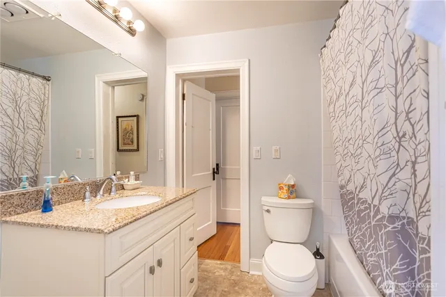 a bathroom with a granite countertop toilet sink and a mirror