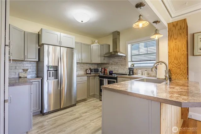 a kitchen with a refrigerator a sink and wooden cabinets