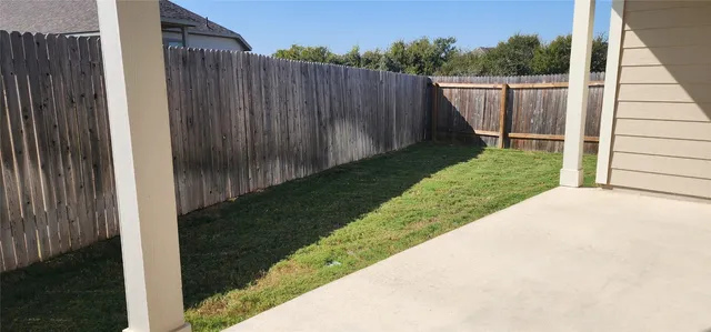 a view of a backyard with wooden fence