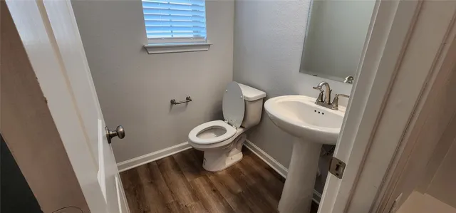 a white toilet sitting next to a sink and vanity