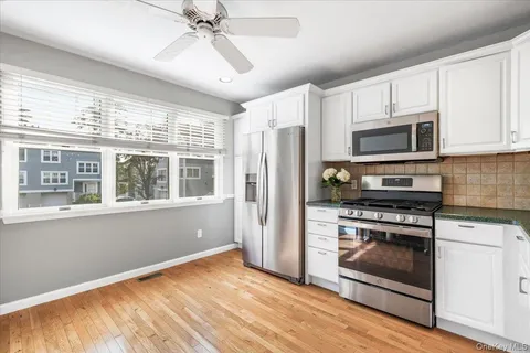 a kitchen with stainless steel appliances granite countertop a stove a refrigerator and a microwave