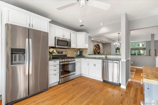 a kitchen with stainless steel appliances a refrigerator sink and microwave