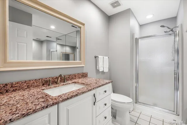 a bathroom with a granite countertop sink a toilet and a mirror