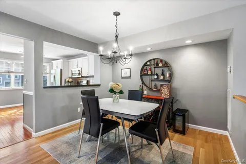 a view of a dining room with furniture a chandelier and wooden floor