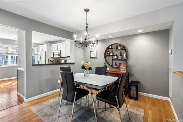 a view of a dining room with furniture a chandelier and wooden floor