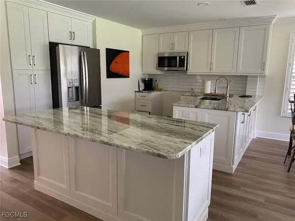 a kitchen with stainless steel appliances granite countertop a refrigerator stove microwave and sink