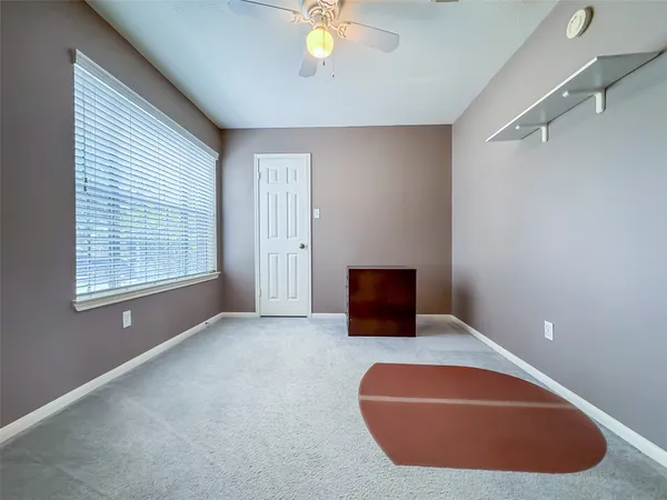 an empty room with fan and windows