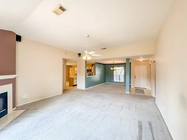 a view of an empty room with window and fireplace