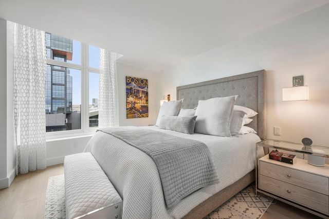 a bedroom with a bed and a large window