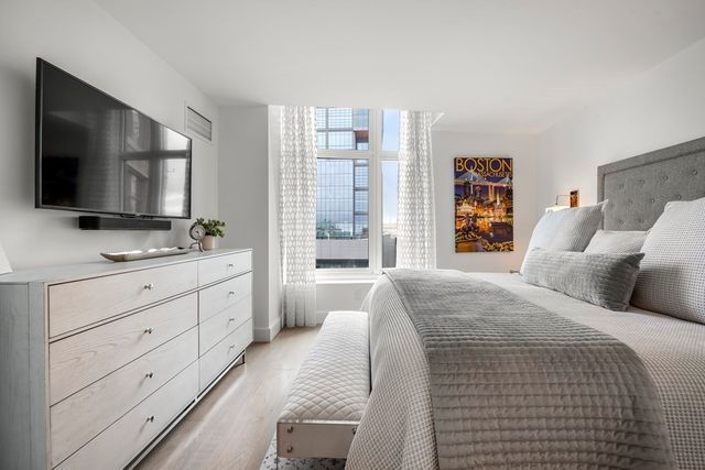 a bedroom with a large bed and a flat screen tv