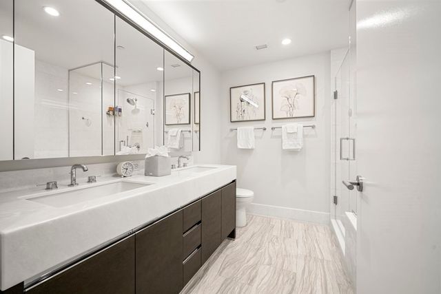 a spacious bathroom with a double vanity sink mirror and shower