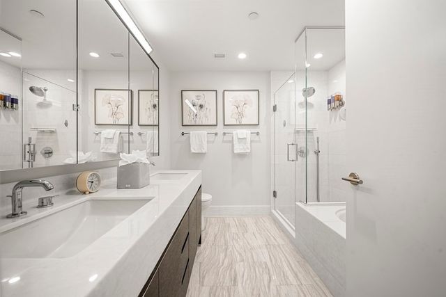 a bathroom with a double vanity sink a mirror and a shower