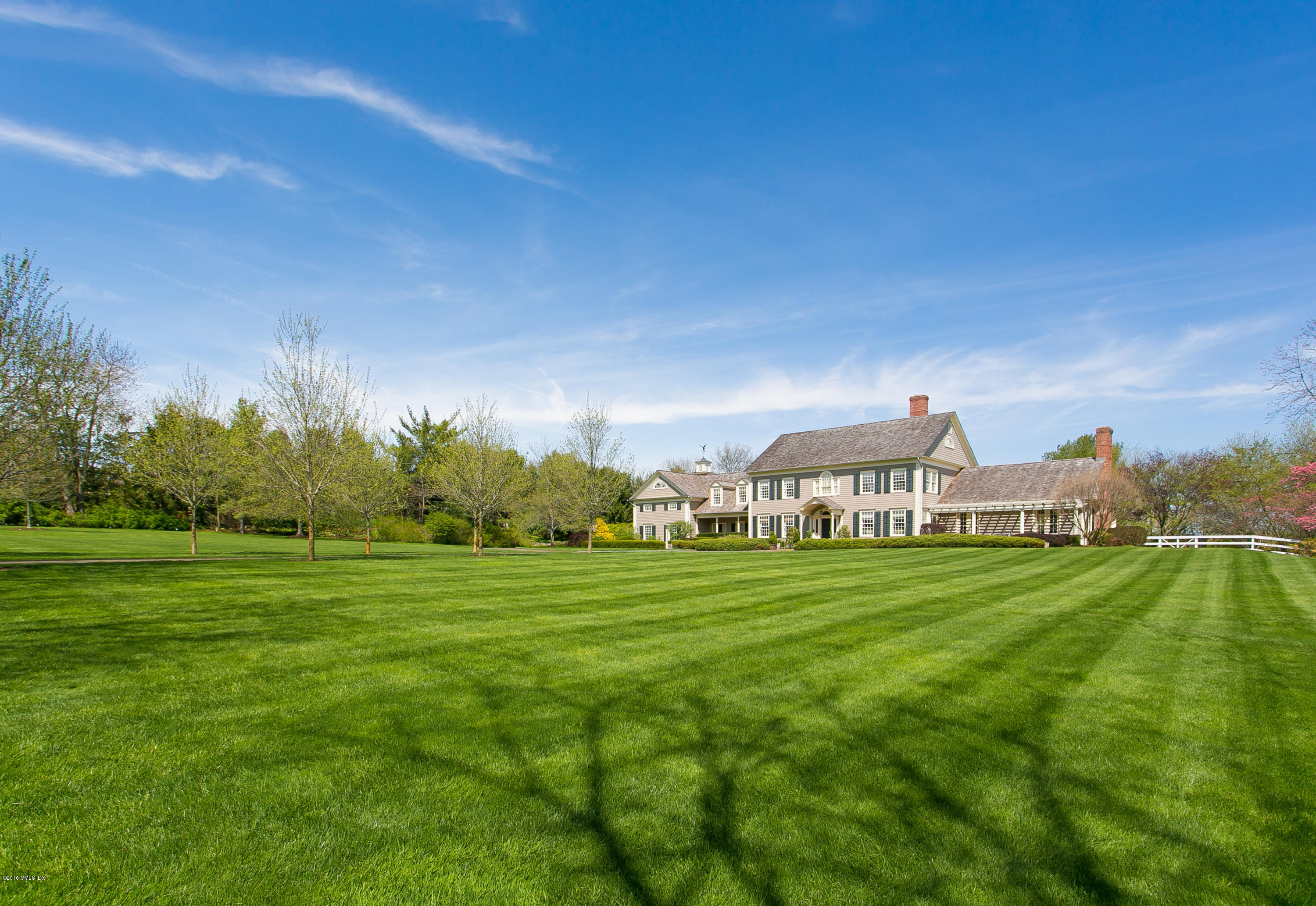 449 Round Hill Road Greenwich, CT 06831 - Photo 2 of 57 a view of a big yard with a house in the background