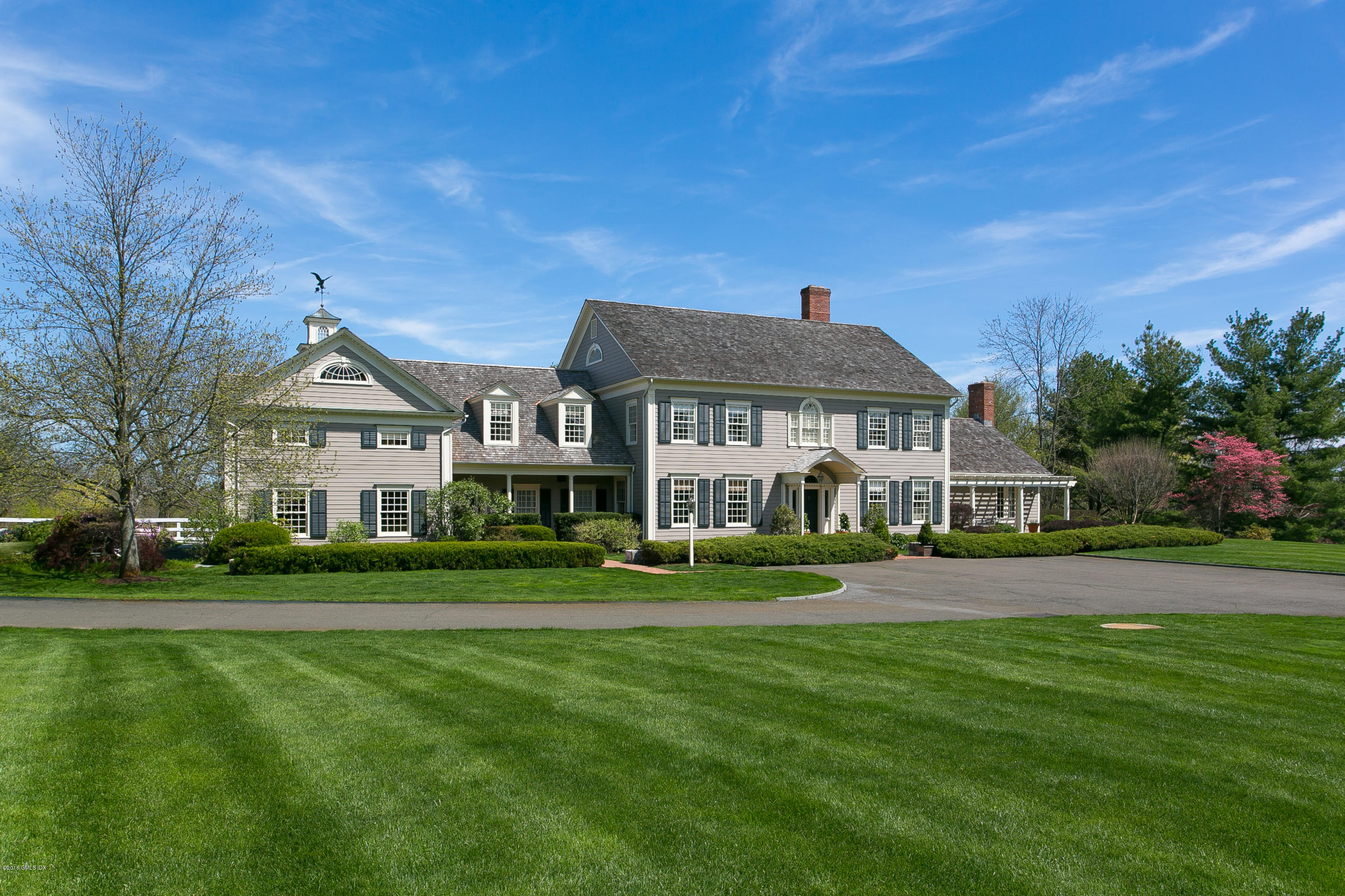 449 Round Hill Road Greenwich, CT 06831 - Photo 3 of 57 a front view of a house with a yard table and chairs
