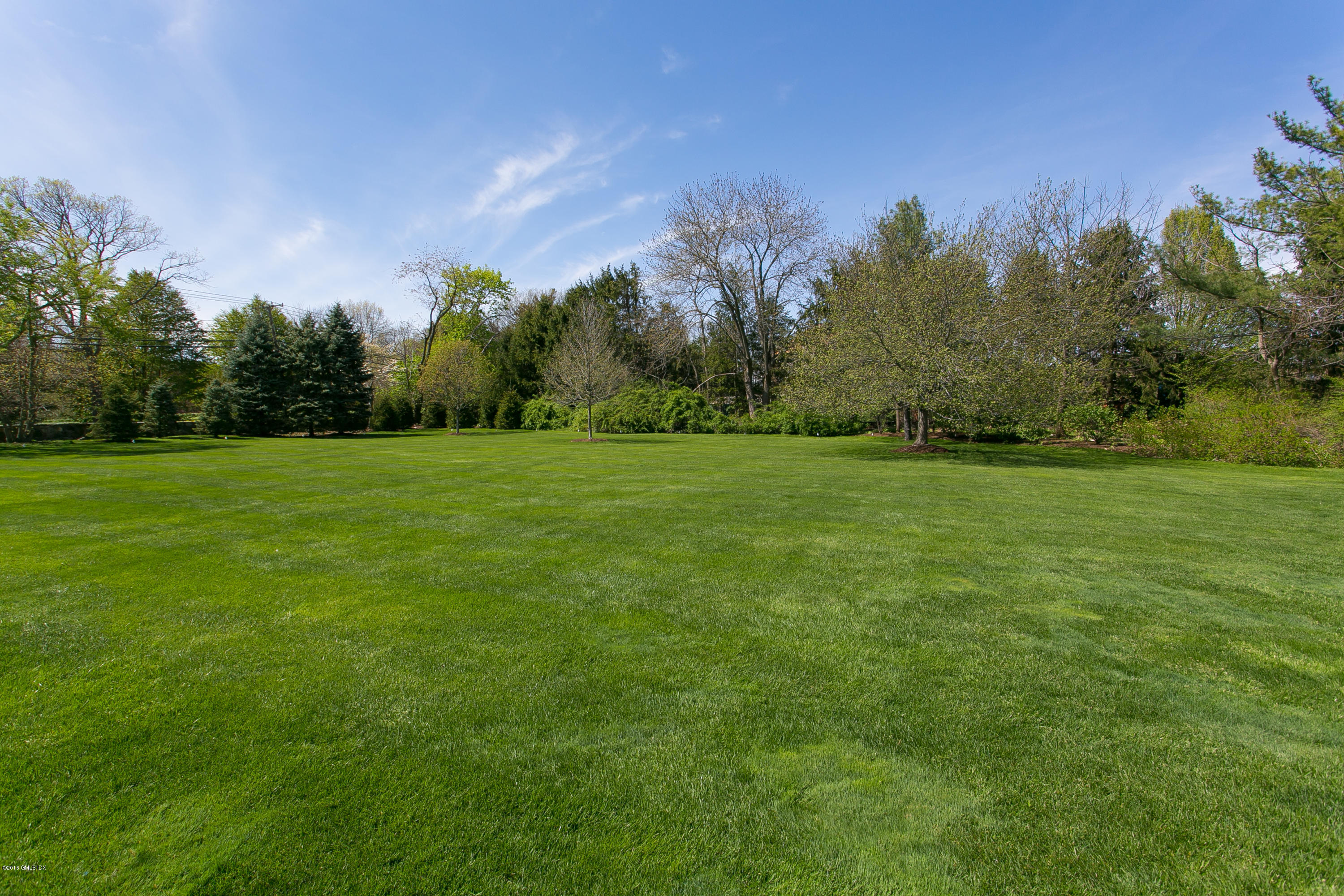 449 Round Hill Road Greenwich, CT 06831 - Photo 50 of 57 a view of a grassy field with trees in the background