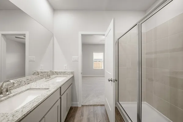 a bathroom with a granite countertop sink a mirror and shower