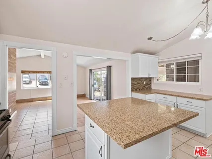 a kitchen with granite countertop a sink and a stove