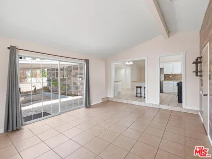 a view of empty room with kitchen