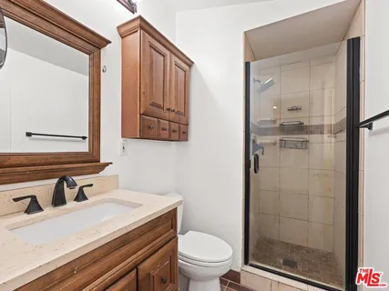 a bathroom with a sink a toilet and shower