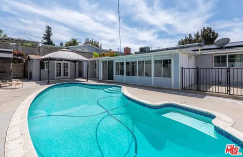 a view of a house with swimming pool and porch