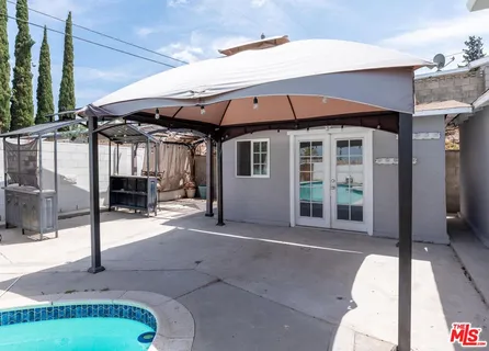 a patio with a table and chairs under an umbrella