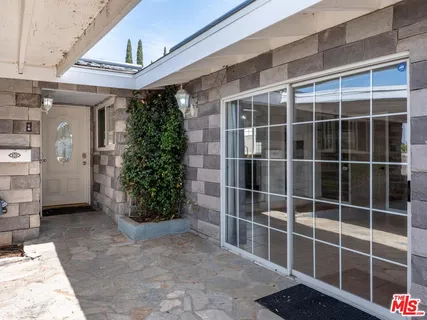 a view of a door with a potted plant and a window