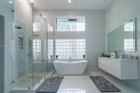 a bathroom with a glass door shower and sink